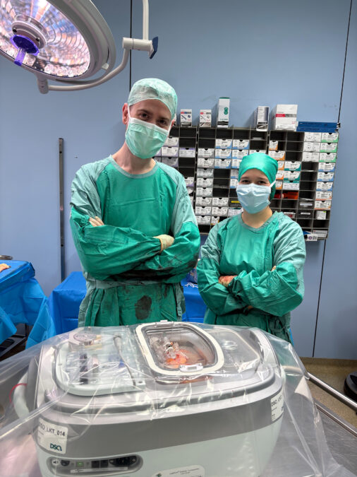 erfolgreiche nierentransplantation (von links): dr. cornelius van beekum, chirurg, und vanessa muth, assistenzärztin, mit der geöffneten maschine, stellvertretend für das transplantationsteam der klinik für allgemein-, viszeral- und transplantationsmedizin.