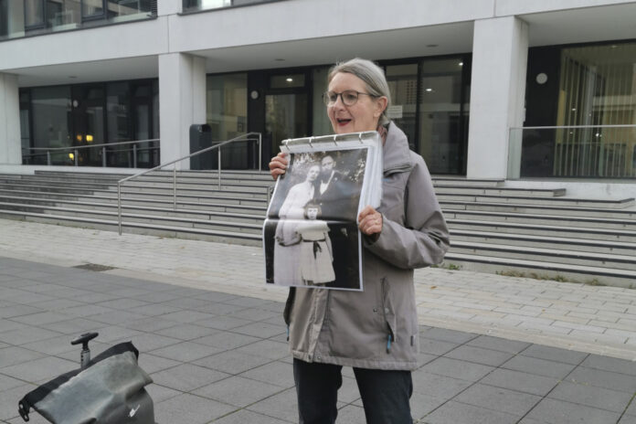Vor dem VHS-Gebäude mit einem Bild von Ada und Theodor Lessing mit Tochter Ruth