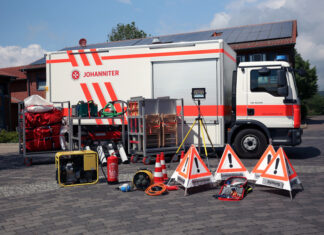 ein gerätewagen sanität (gw-san) der johanniter mit teilen seines materials davor.