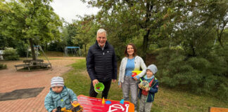 Vom Wunsch zur Wirklichkeit: Erste Sandspielzeugkiste in Langenhagen eröffnet. Hinter der Kiste, v.l.n.r. Mirko Heuer, Annelie Dobewall mit KIndern.