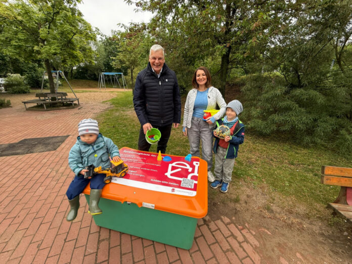Vom Wunsch zur Wirklichkeit: Erste Sandspielzeugkiste in Langenhagen eröffnet. Hinter der Kiste, v.l.n.r. Mirko Heuer, Annelie Dobewall mit KIndern.