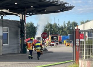 abc-großeinsatz bei spedition in lehrte: gefahrstoffbrand am frühen morgen blick auf die einsatzstelle mit der qualmenden wechselbrücke