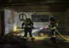 feuerwehr bokeloh löscht im inneren einer scheune mehrere glutnester in strohresten.
