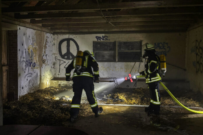 Feuerwehr Bokeloh löscht im Inneren einer Scheune mehrere Glutnester in Strohresten.