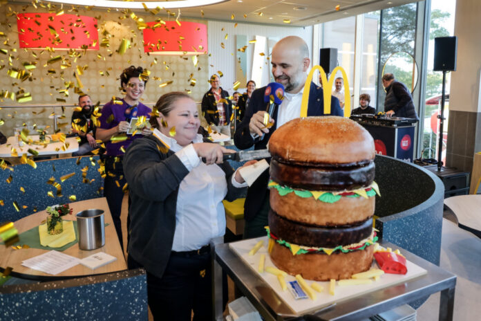 McDonald’s-Franchisenehmer David Ehmann und Restaurantleiterin Nadeschda Maier schneiden gemeinsam den Big-Mac-Kuchen an.