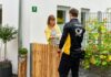 themenfoto: ein verbundzusteller liefert einer kundin ein paket und ein werbemailing.